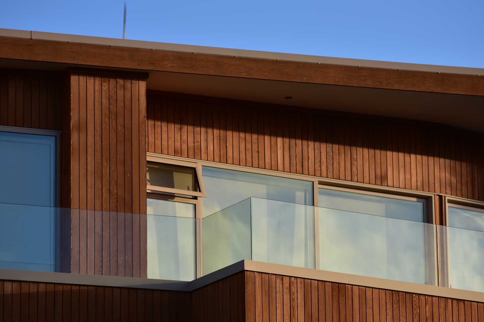 Deck on second storey house with dark timber panelling